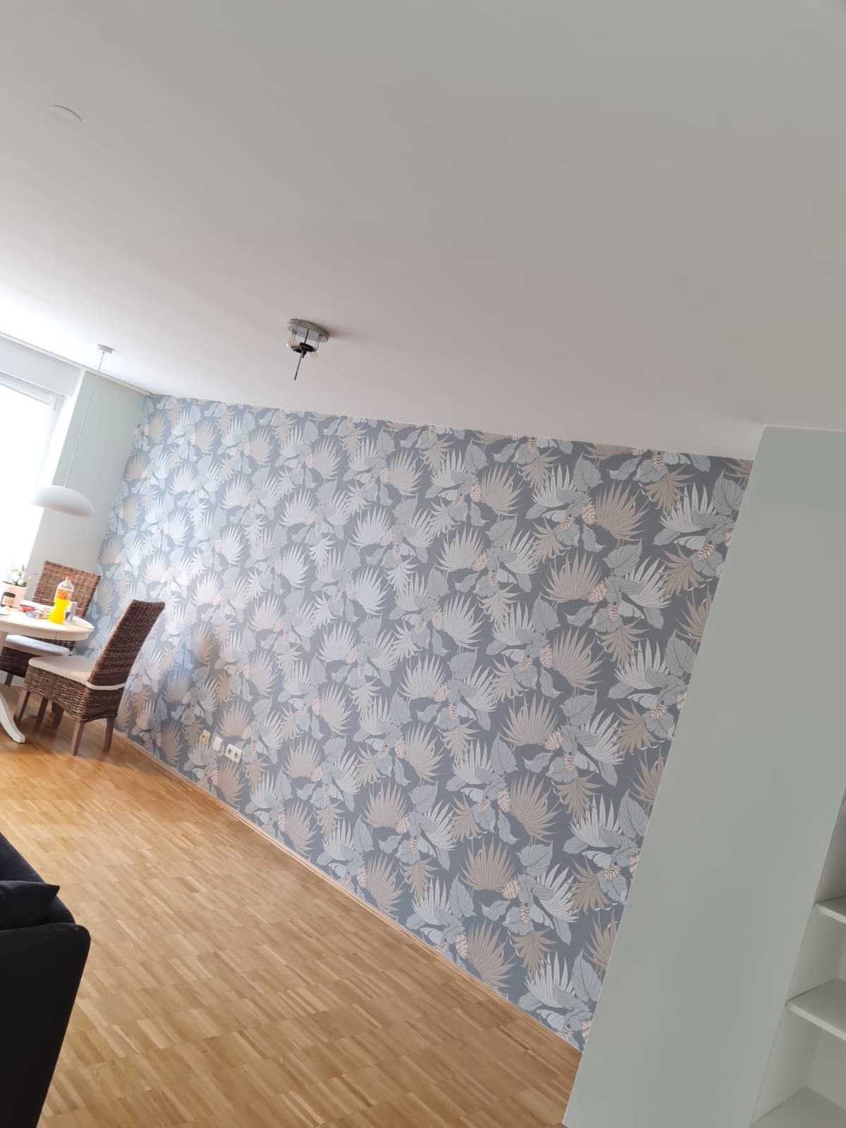 Wand mit Blätter-Tapete in einem Wohnraum