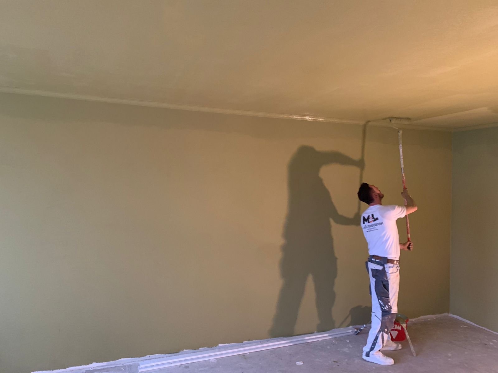 Maler bei Arbeiten an Wand und Decke