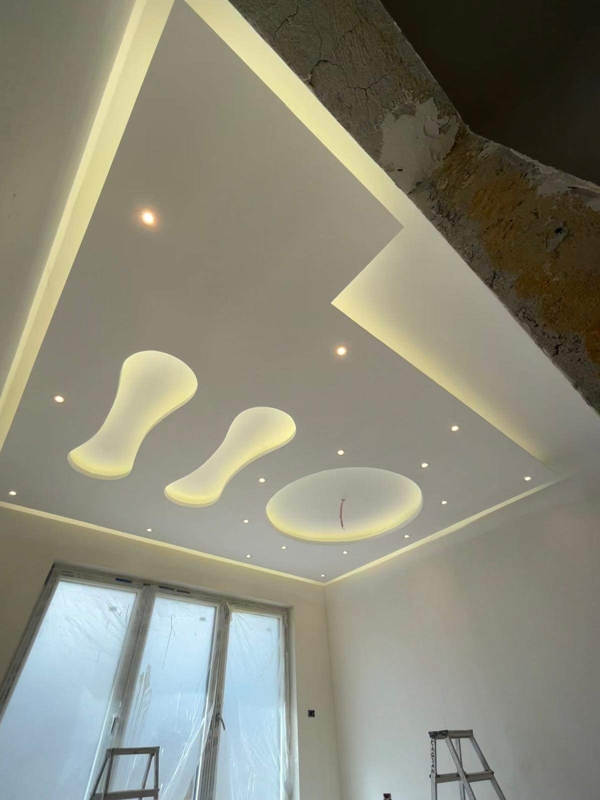 Fertiggestellte Trockenbau-Decke mit geschwungenen Lichtvouten und LED-Beleuchtung